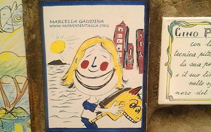La caricatura di Marcella Gaudina e il sito internet di Mondointasca sulla mattonella 