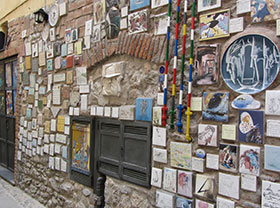 Il muretto con le mattonelle e le opere degli artisti di passaggio ad Albenga