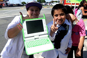 Ragazzi che mostrano il computer che gli è stato consegnato dalla scuola