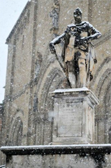 La statua di Ferdinando I de' Medici davanti al Duomo di Arezzo innevato 