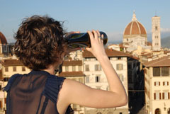 Un'immagine promozionale dell'evento con una ragazza che osserva Firenze con un binocolo fatto di bottiglie