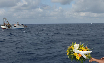 Mazzi di fiori lanciati in mare dai pescatori di Lampedusa in memoria degli immigrati morti nel tragico naufragio delle scorse settimane (Afp/Alberto Pizzoli)
