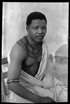 Eli Weinberg, Nelson Mandela ritratto mentre indossa perline tradizionali ed è avvolto in un lenzuolo.  Qui si nascondeva dalla polizia durante il periodo trascorso come versione nera della  'primula rossa' 1961. Per gentile concessione di IDAFSA.
