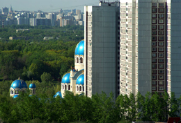 Un'immagine che esprime bene il carattere di Mosca: le cupole celesti di una chiesa si stagliano sul profilo di un anonimo palazzone moderno