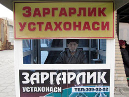 Uzbekistan Un venditore d'oro che si pubblicizza in cirillico al mercato di Samarcanda