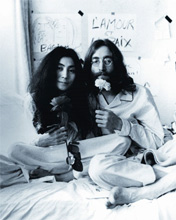 Yoko Ono e John Lennon con un fiore in mano in segno di pace